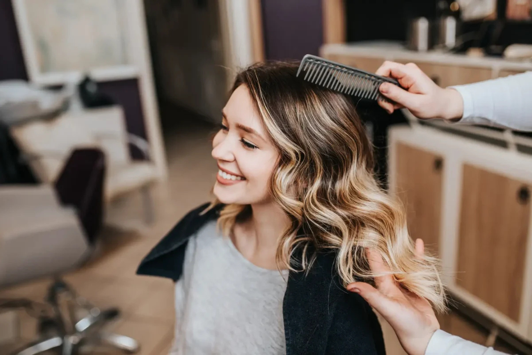 Junge Frau beim Friseur, Friseur betrachtet Ihre Haare